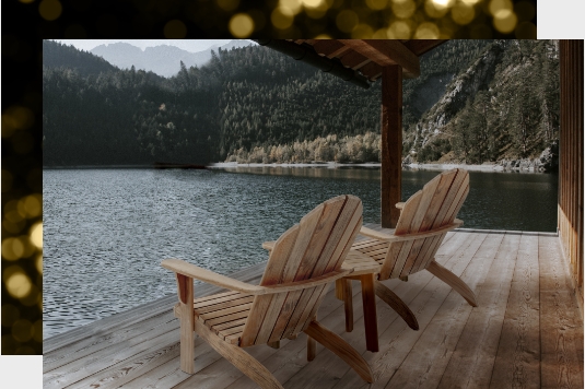 Adirondacks & Rocking Chairs on a deck by a lake.