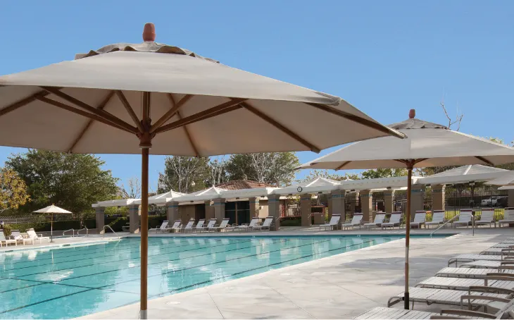 Various umbrellas and chaise loungers around a pool.