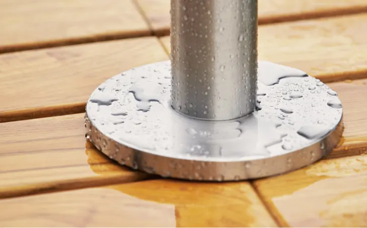 An umbrella base wet with rain drops.