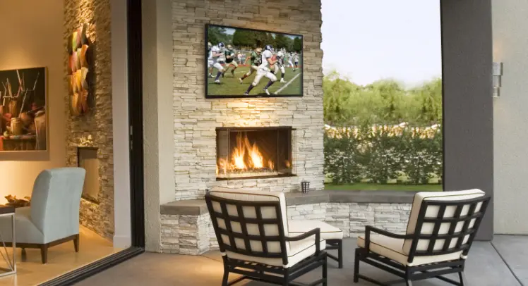An outdoor TV in the middle of a sitting area.