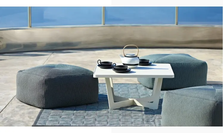 Various ottomans on the floor by a small white table.