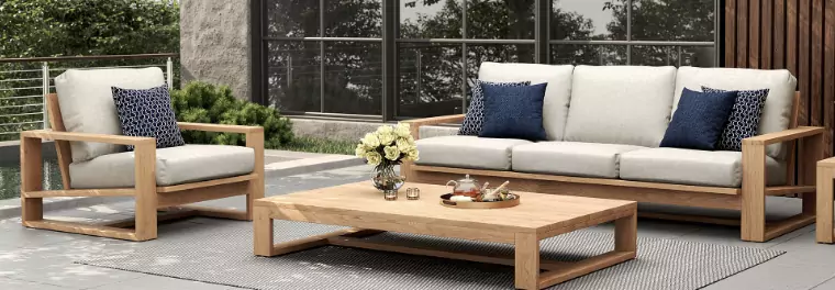 A sofa and a chair with a large table in front.