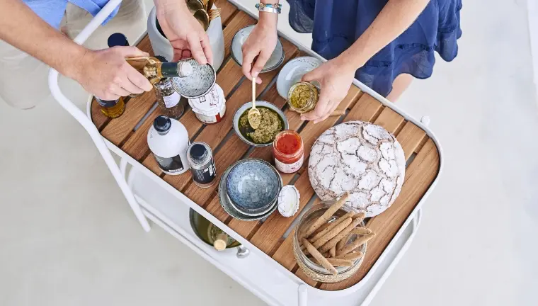 A barcart filled with food and two people serving themselves.