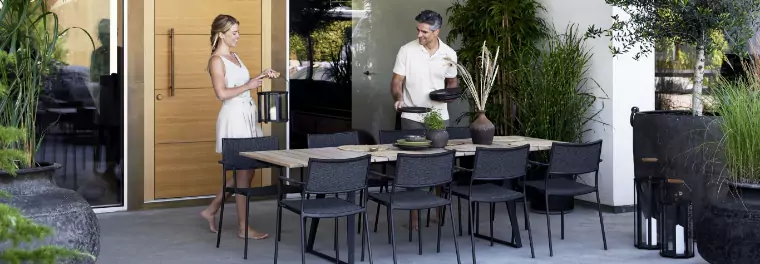 A man and woman standing by a dining table.