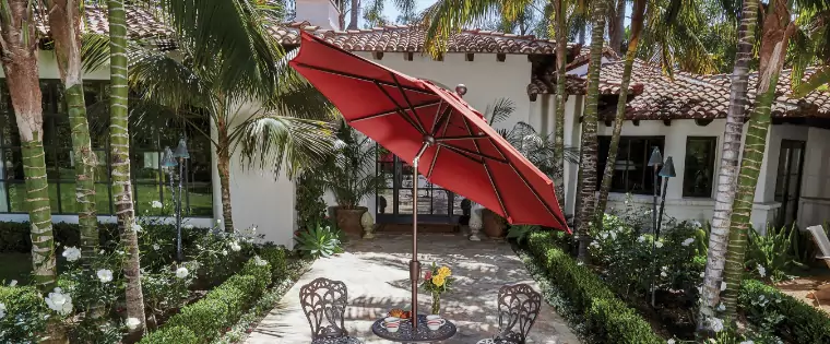 A red umbrella covering a small round table.