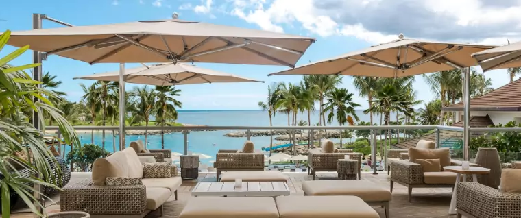 Various brown umbrellas on an outdoor sitting area by a beach.