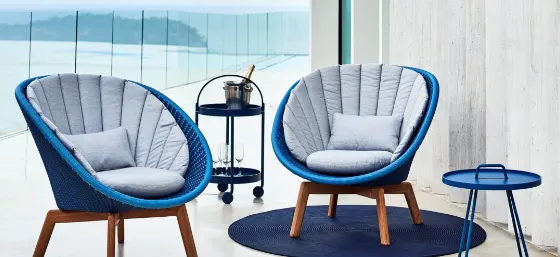 Two blue chairs by a small blue metal side table.