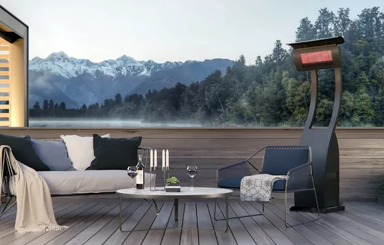 A freestanding heater on a deck by a sofa and small round table.