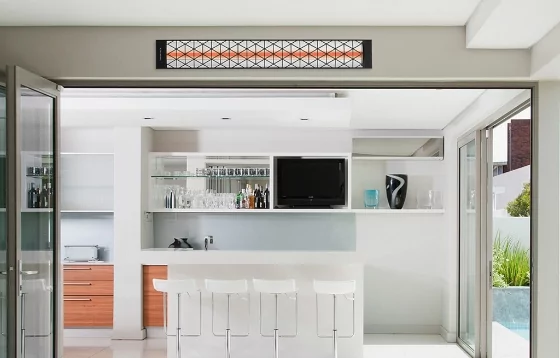 A heater mounted on the wall by an outdoor kitchen.
