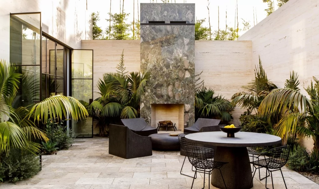 An outdoor sitting area with a round table and some metal chairs.