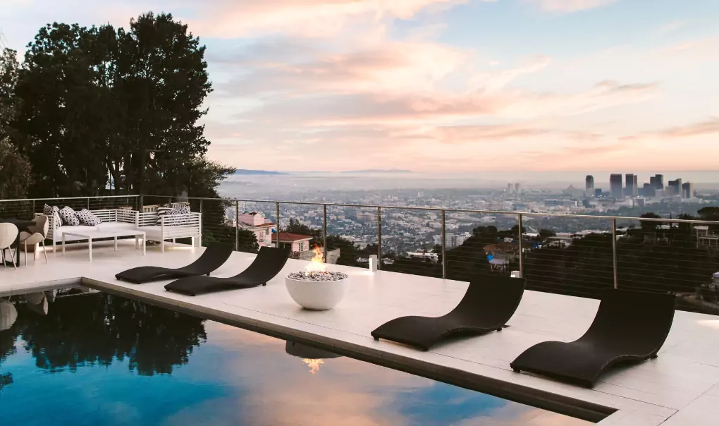 A pool on a rooftop with a skyline in the horizon.