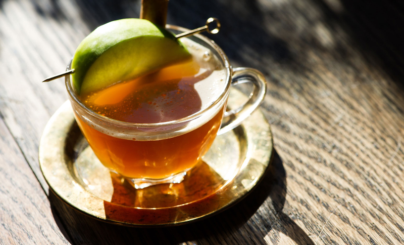 A cup of Wassail, an orange drink with a slice of lime