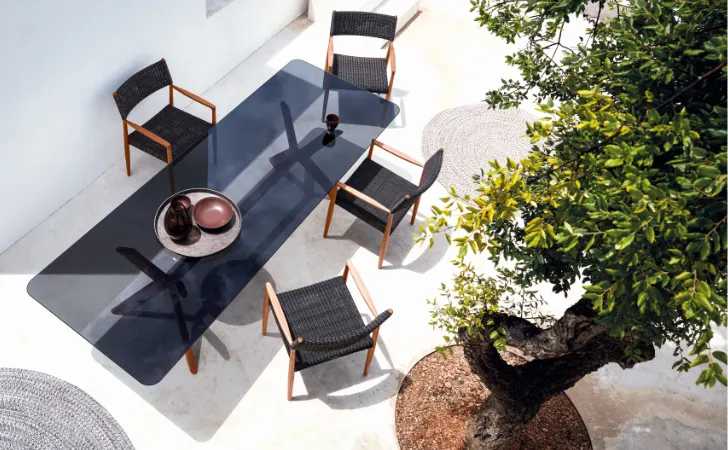 A glass dining table with four chairs.