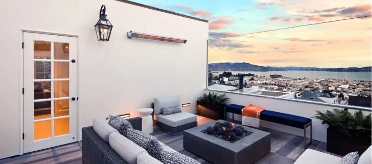 A wall mounted heater next to a rooftop seating area.