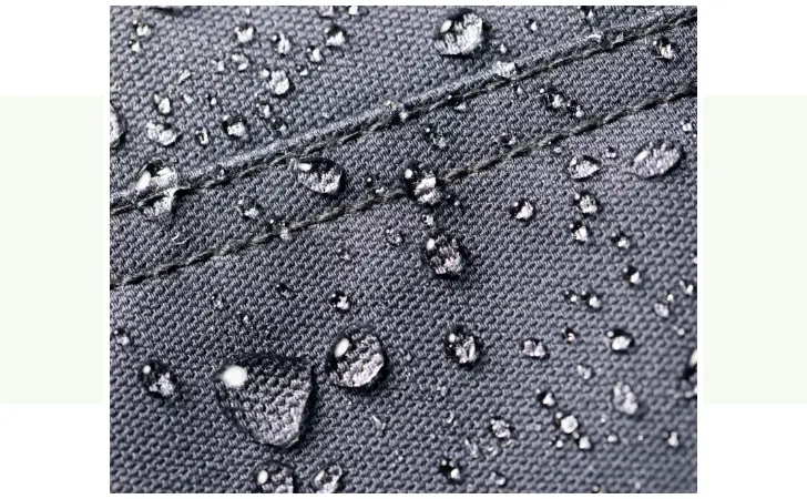 A close up of upholstery with rain drops.