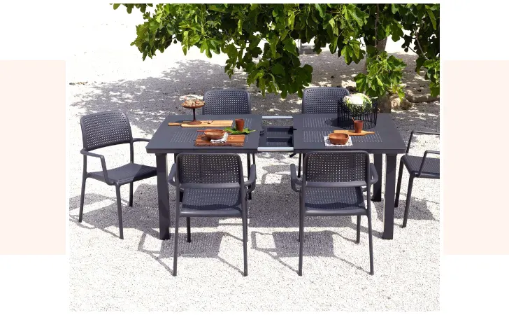 A dark gray dining table with six chairs.