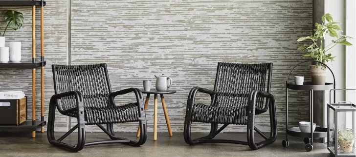 Two chairs with a round small table next to them.
