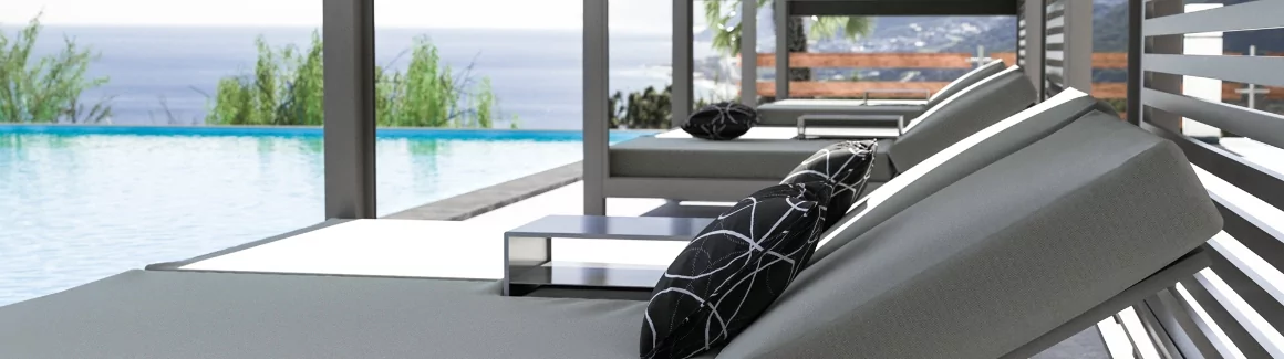 Various daybeds in front of a pool.