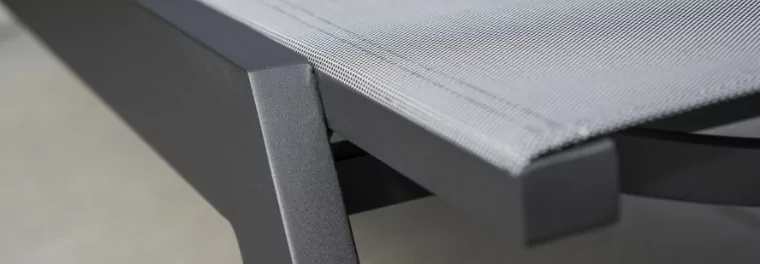 A close up of a metal chair with a sling feature.
