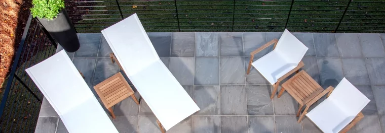 Two chaise loungers and two chairs on a patio.