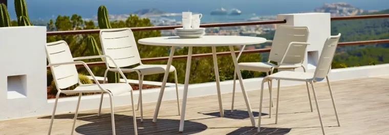 A wicker sofa and chairs with a table in between.