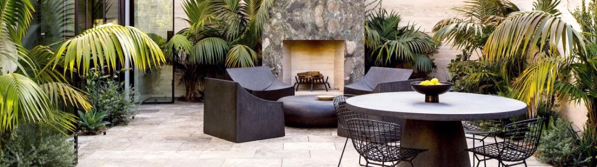 Various pieces of furniture in front of an outdoor fireplace.