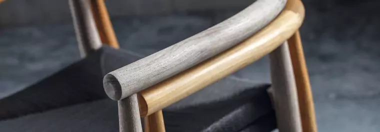 A close up of the back of a teak chair.