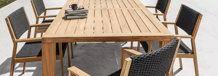 A teak dining table with five chairs.