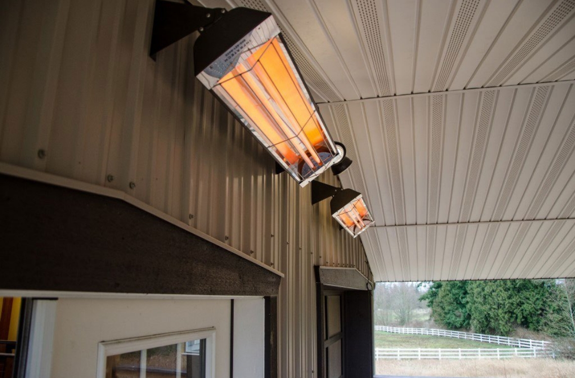 Two electric heaters mounted on a wall of an outdoor patio space