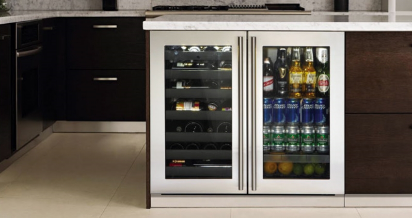 A wine and can cooler in a cabinet.